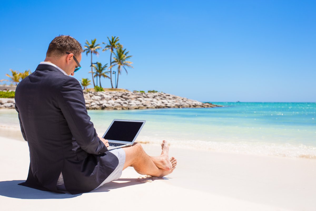 Businessman using laptop computer on the beach
